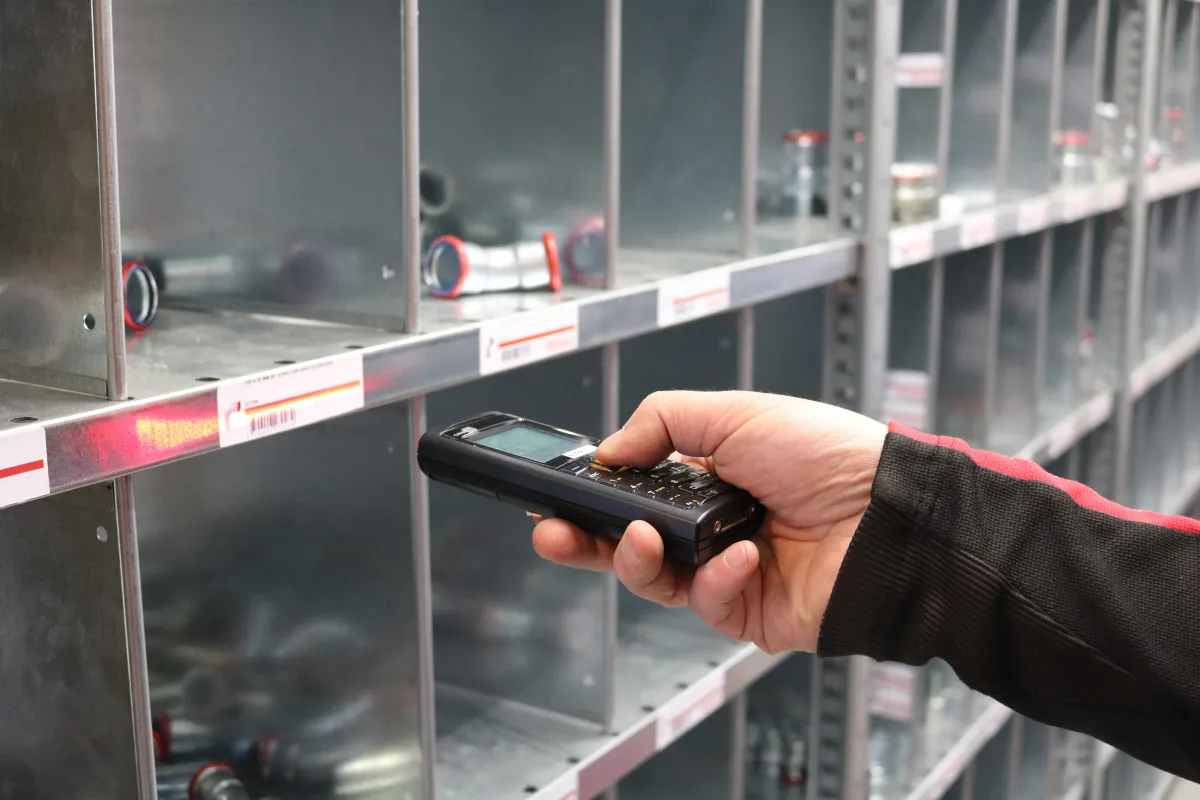 Profissional conferindo mercadorias com leitor de código de barras.
