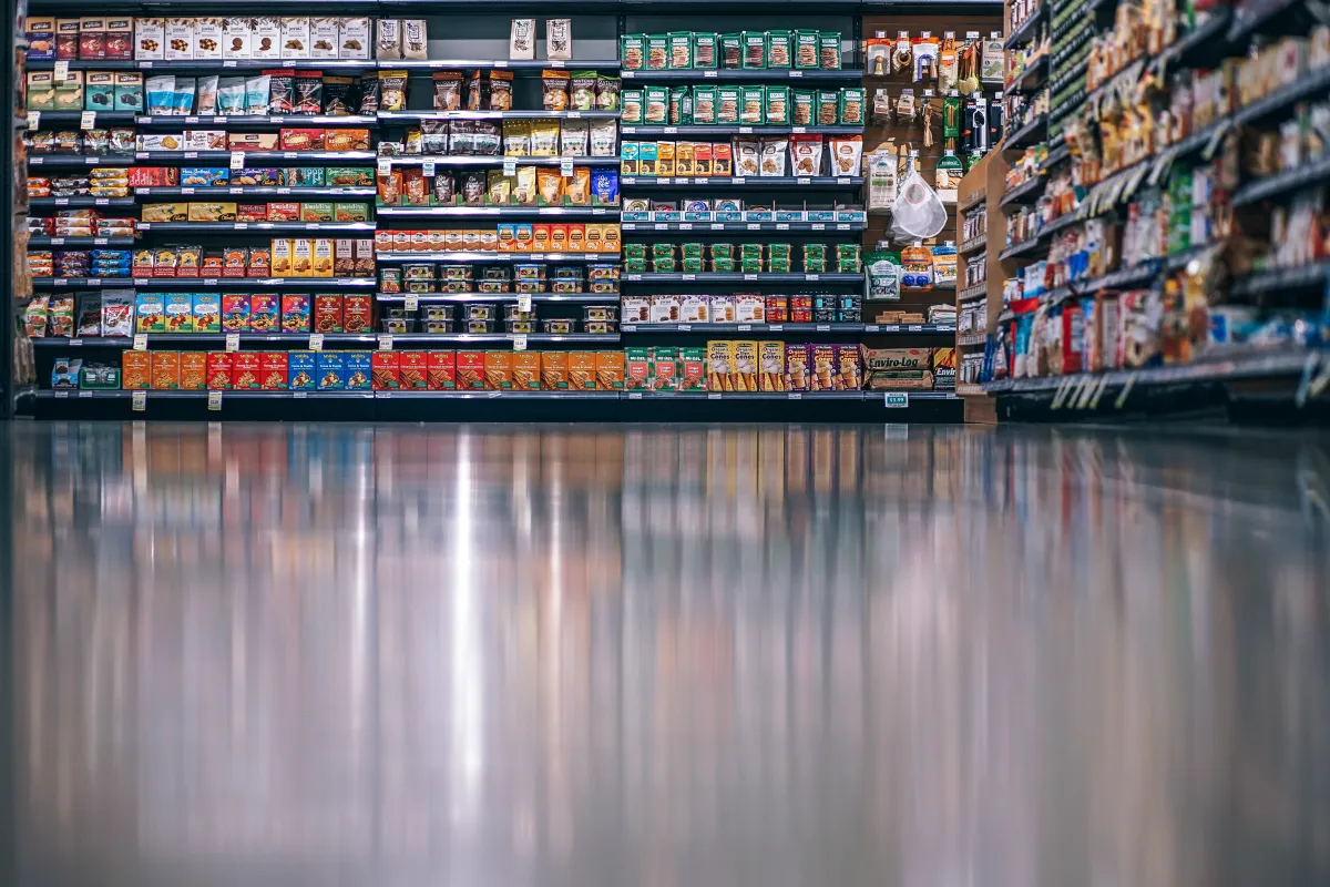 Corredor de supermercado com mercadorias organizadas nas prateleiras.