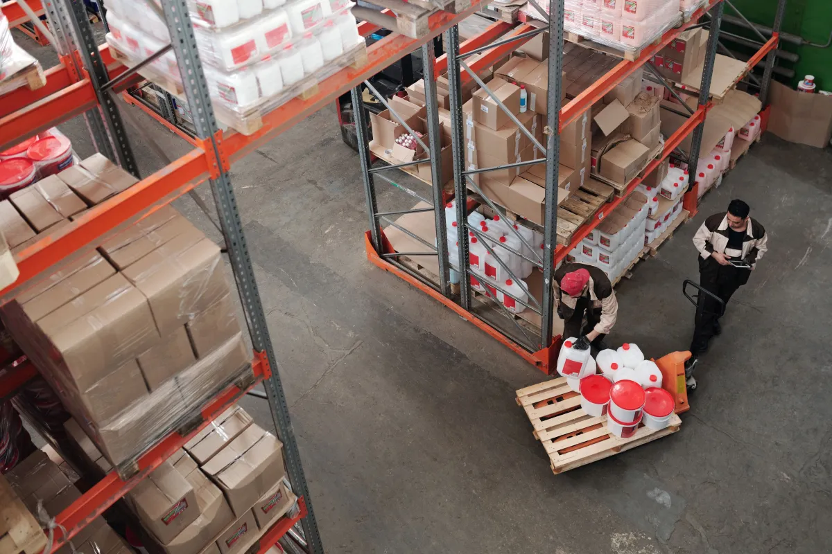 Funcionários organizando mercadorias em depósito durante a rotina de controle de estoque.