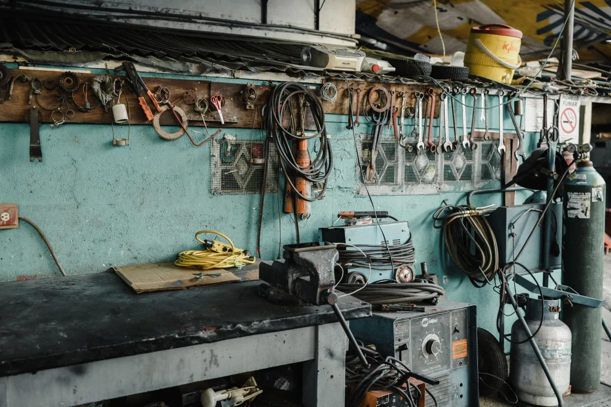 O que é FIFO Estoque? Entenda como funciona na prática com uma imagem de um ambiente industrial e bancada de ferramentas, representando a organização de materiais e o controle de e