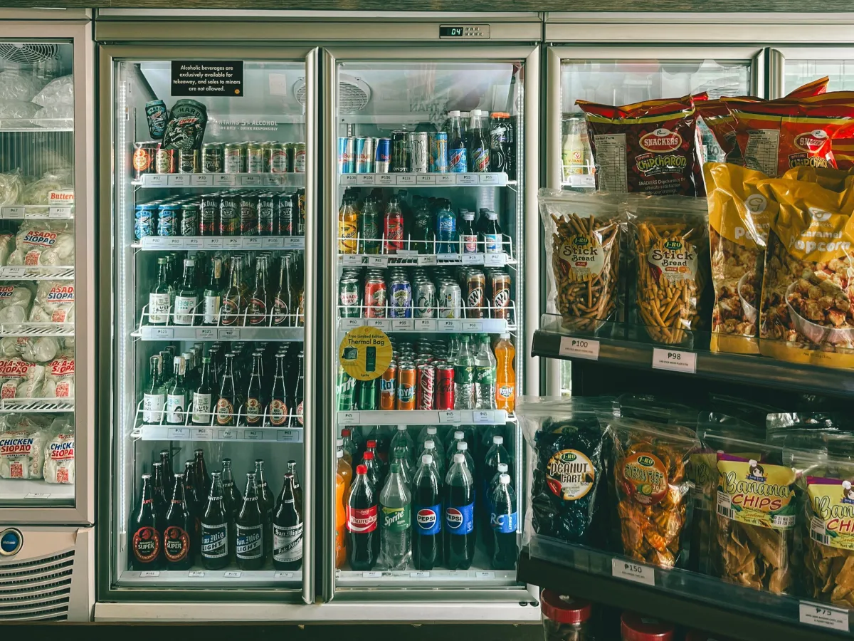 Refrigeradores com bebidas organizadas, relacionados aos cuidados com armazenamento e validade.