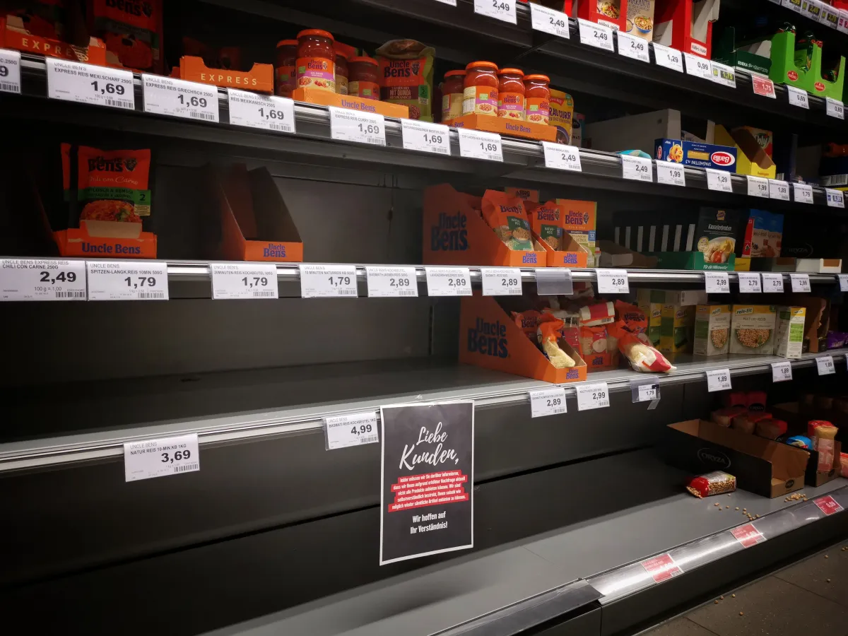 Fotografia de prateleiras parcialmente vazias, representando problemas de reposição.