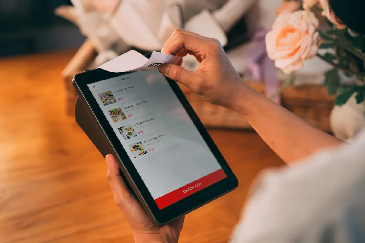 Equipamento de pagamento digital em uso, com enquadramento próximo.