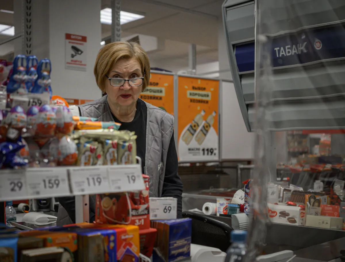 Operadora de caixa atendendo em um estabelecimento comercial com produtos expostos.