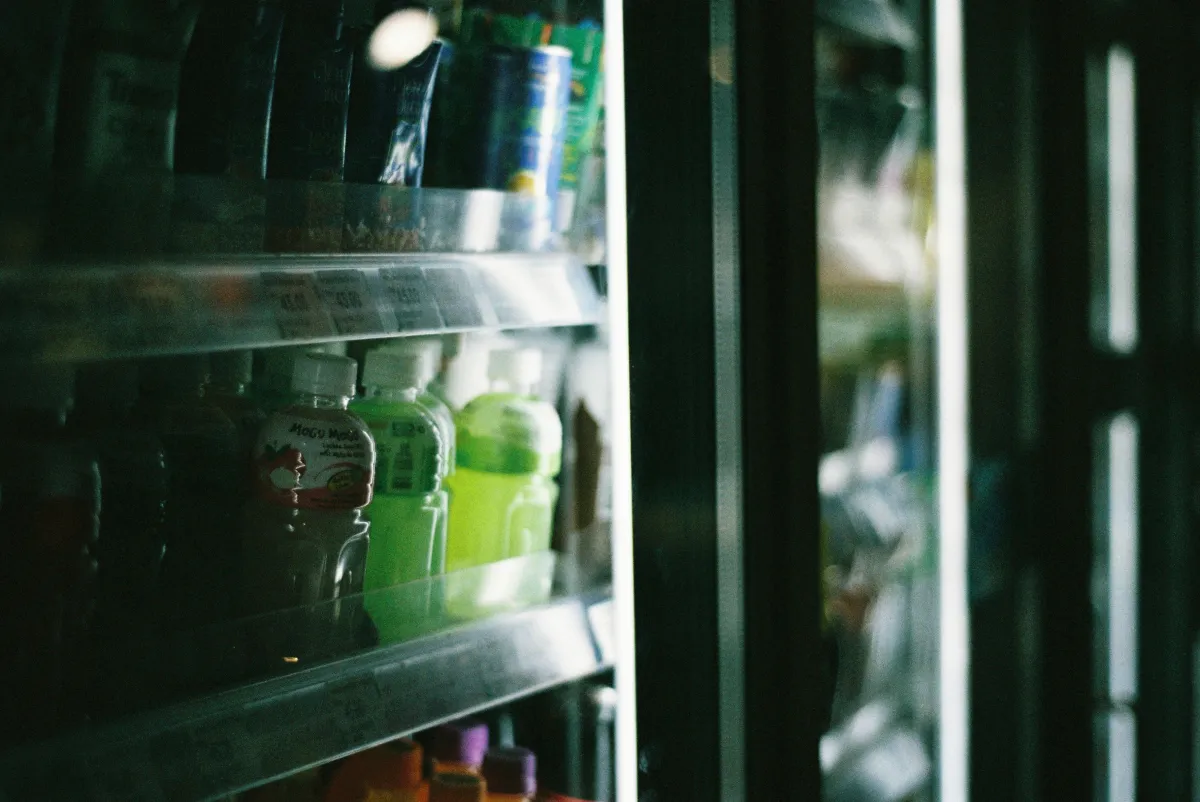 Bebidas variadas organizadas no refrigerador de um estabelecimento comercial.
