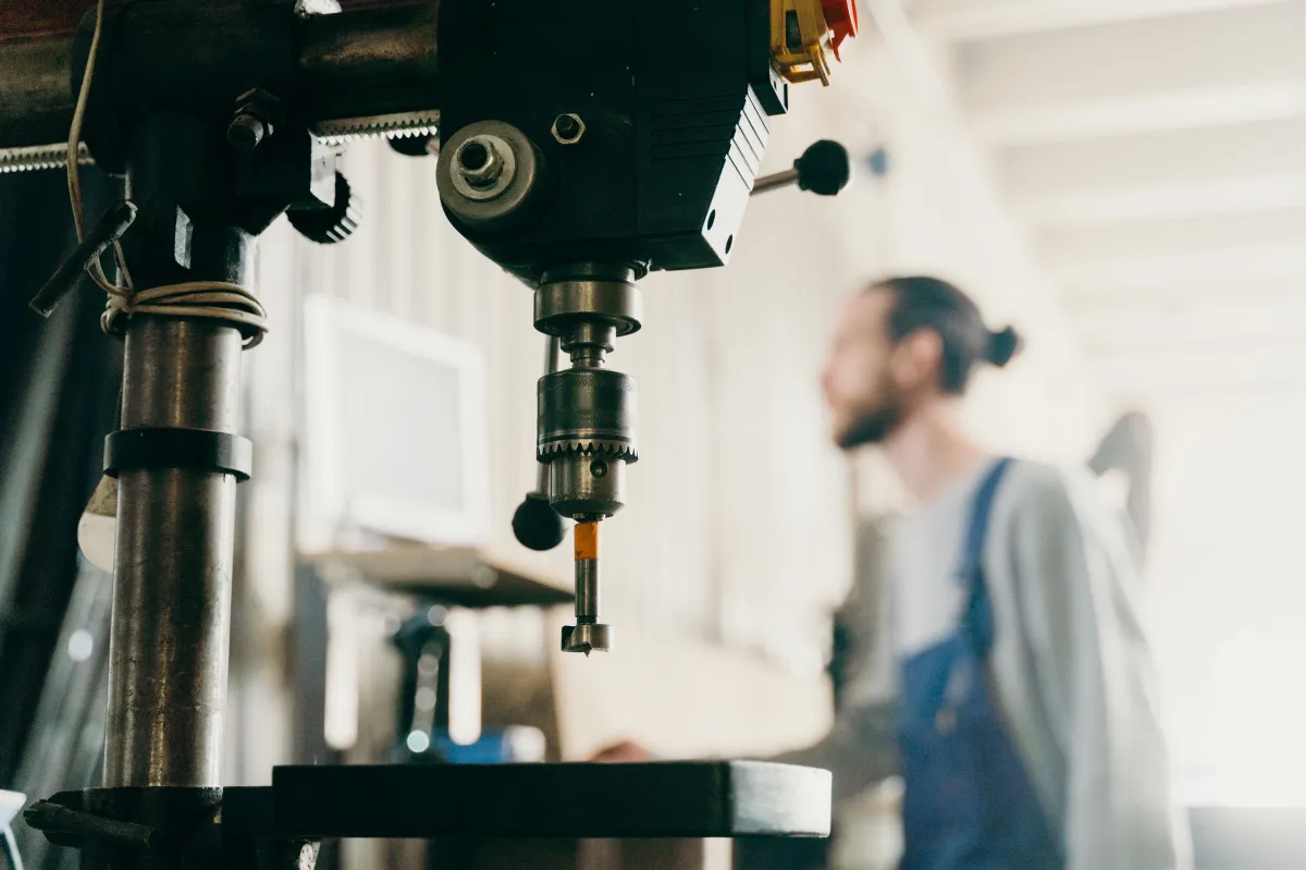 Técnico realizando conferência em equipamento industrial antes de ajustar a sequência de fabricação