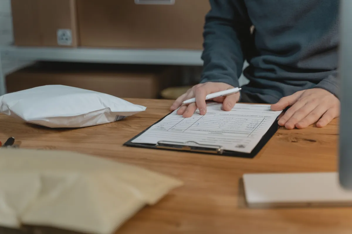 Funcionário conferindo mercadorias e quantidades no estoque de uma distribuidora.