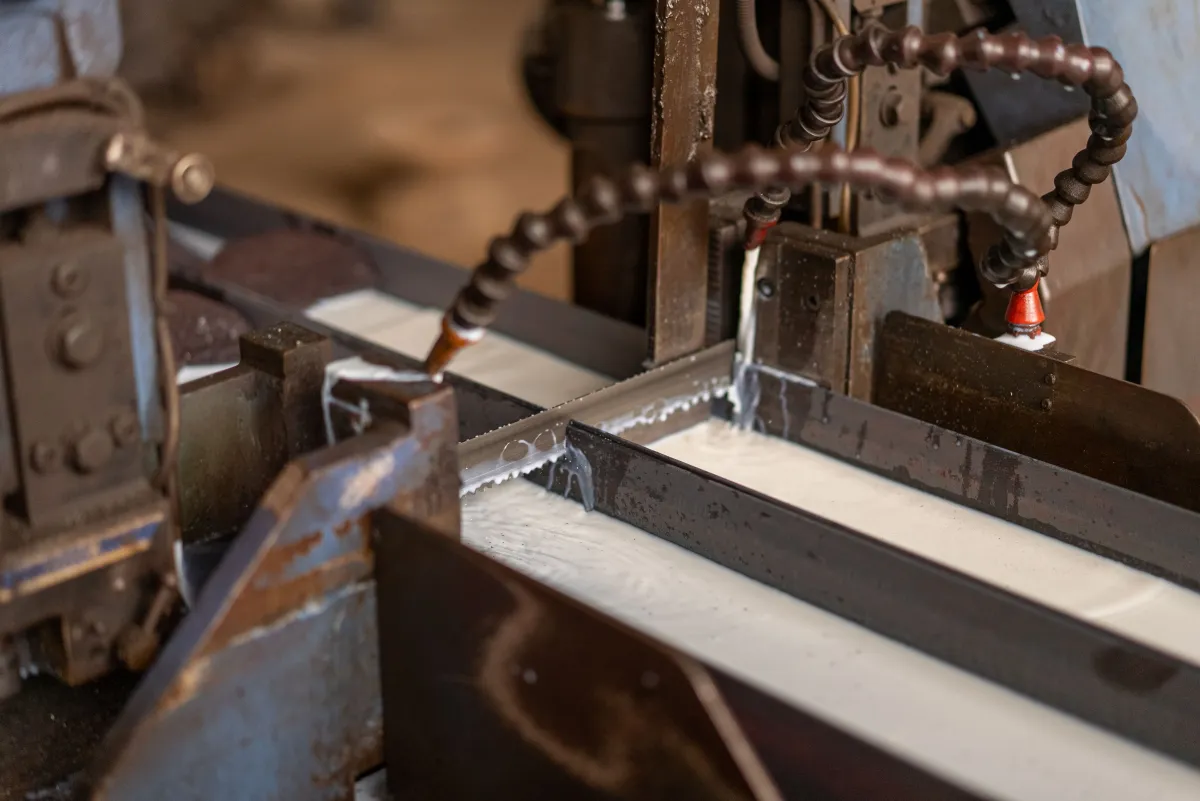 Fotografia aproximada de uma máquina realizando o corte de metal.