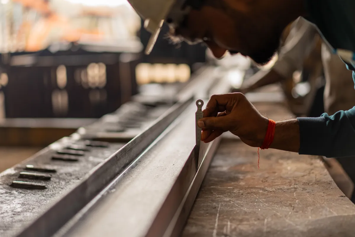 Operador realizando corte de metal em oficina industrial durante o processo de fabricação