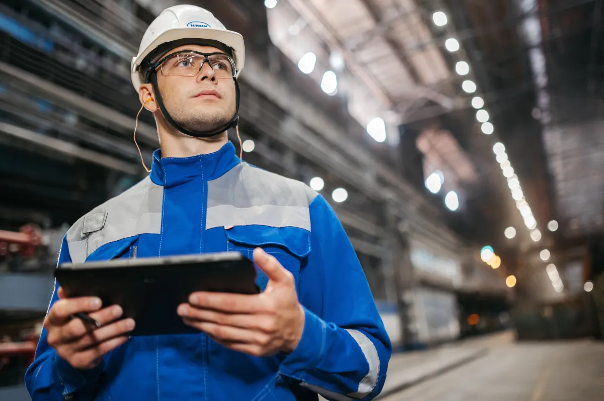Profissional utilizando tablet para acompanhar informações da produção industrial.