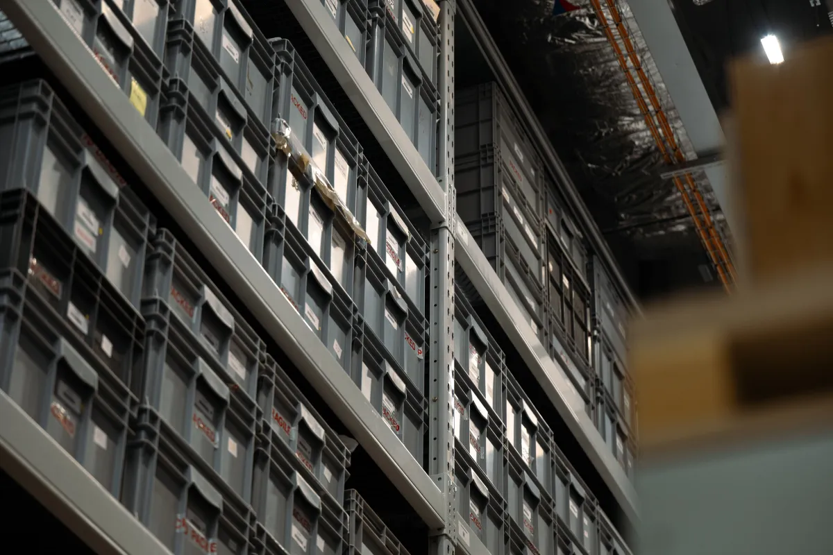 Prateleiras industriais com caixas de armazenamento organizadas.
