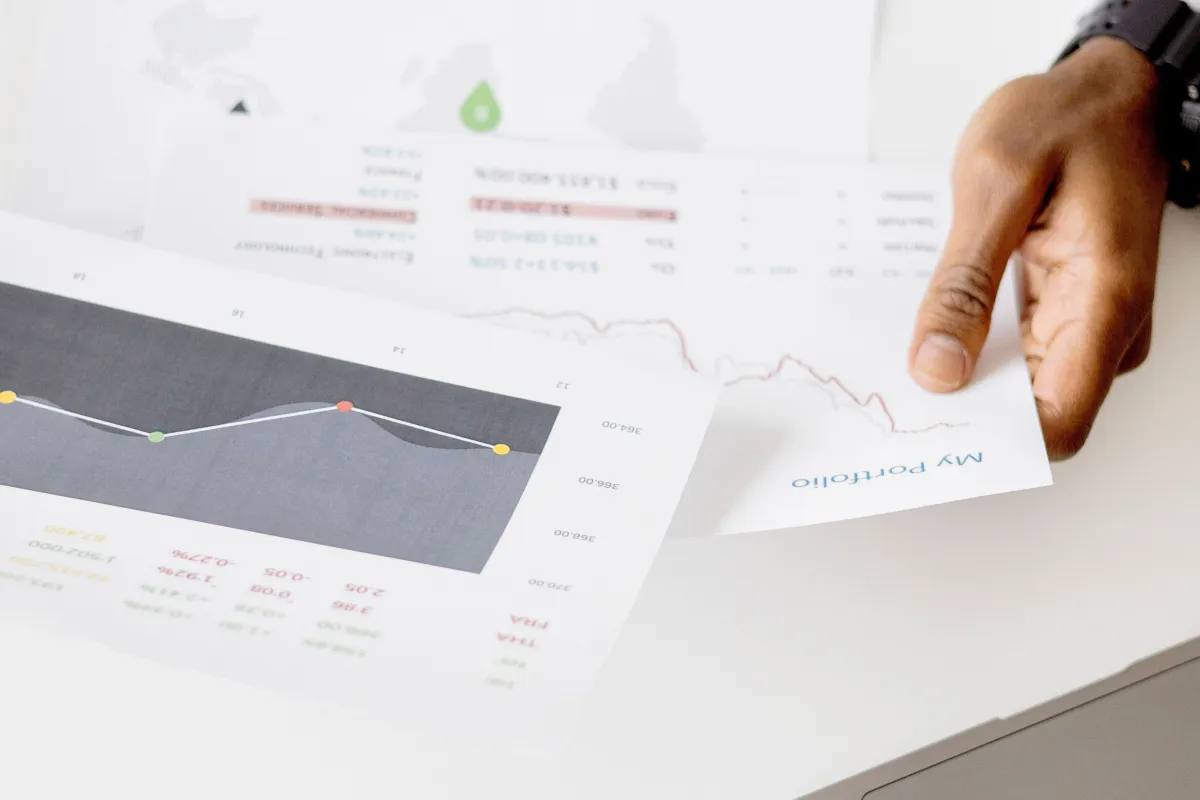 Profissional analisando gráficos e relatórios de desempenho empresarial em um notebook