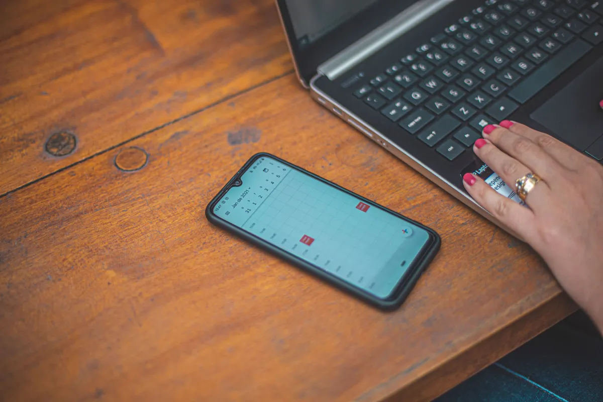 Notebook e smartphone utilizados para organizar atividades administrativas da empresa.