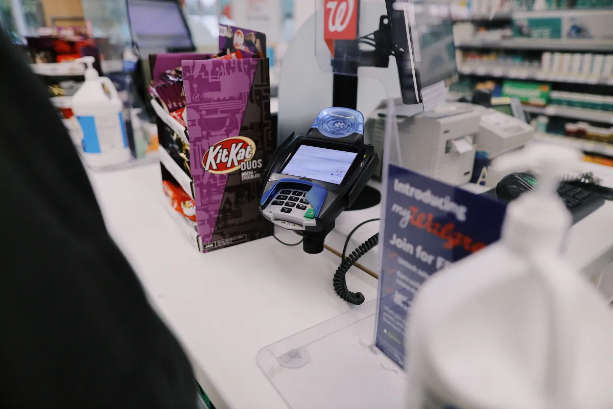 Foto de um balcão comercial com terminal de pagamento e produtos.