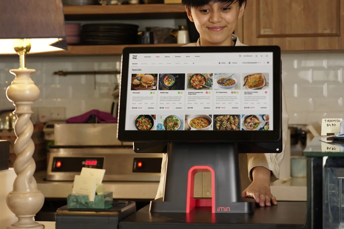 Sistema para Comércio: Pessoa em loja usando um tablet com sistema de vendas exibindo itens e preços para vender mais na Black Friday sem comprometer o lucro, com leitor de caixa a