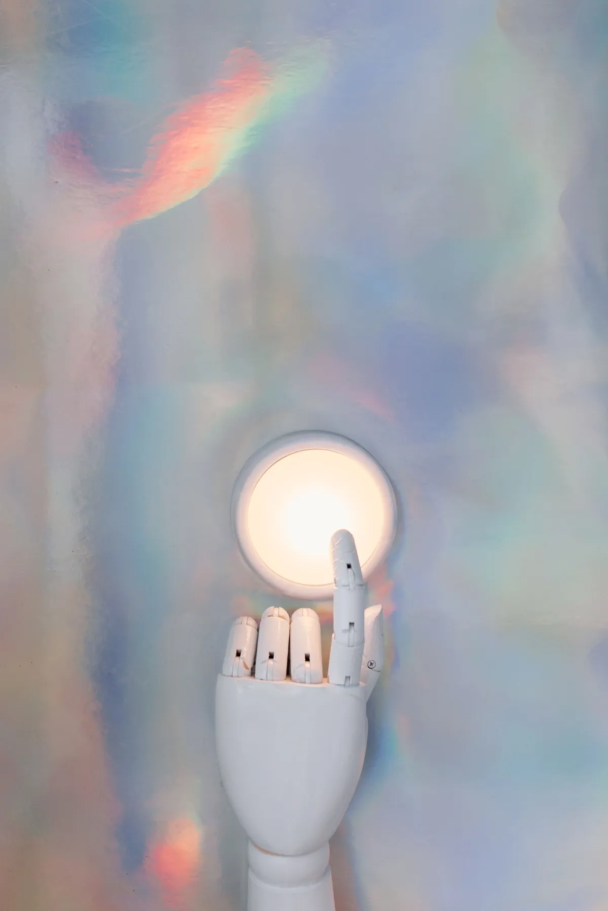 Gestão com IA: Close em um braço robótico branco com luz circular embutida e dedos mecânicos, em fundo suave com efeito holográfico colorido, sugerindo tecnologia e automação