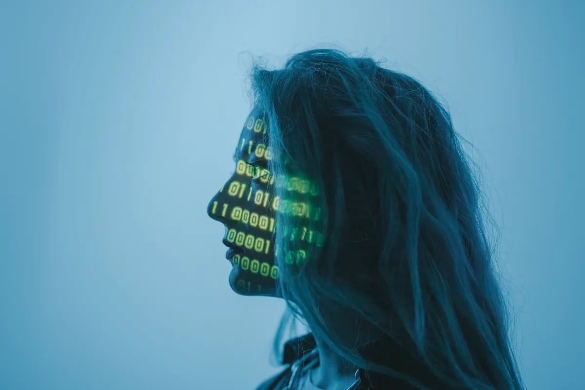 Mulher em perfil com a silhueta iluminada por dados digitais e códigos verdes sobre um fundo azul, simbolizando Gestão com IA e análise de informações